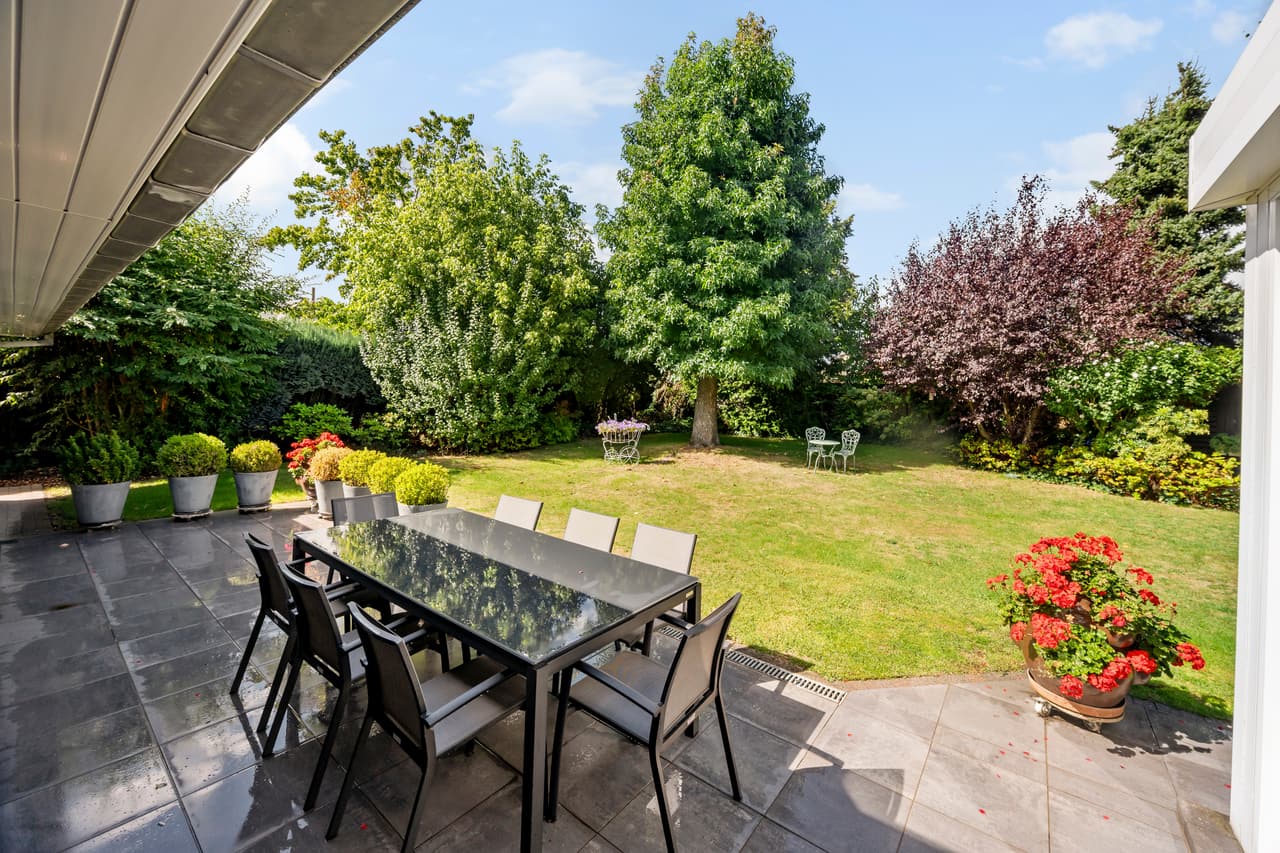 Overdekt terras met eettafel en zicht op de tuin