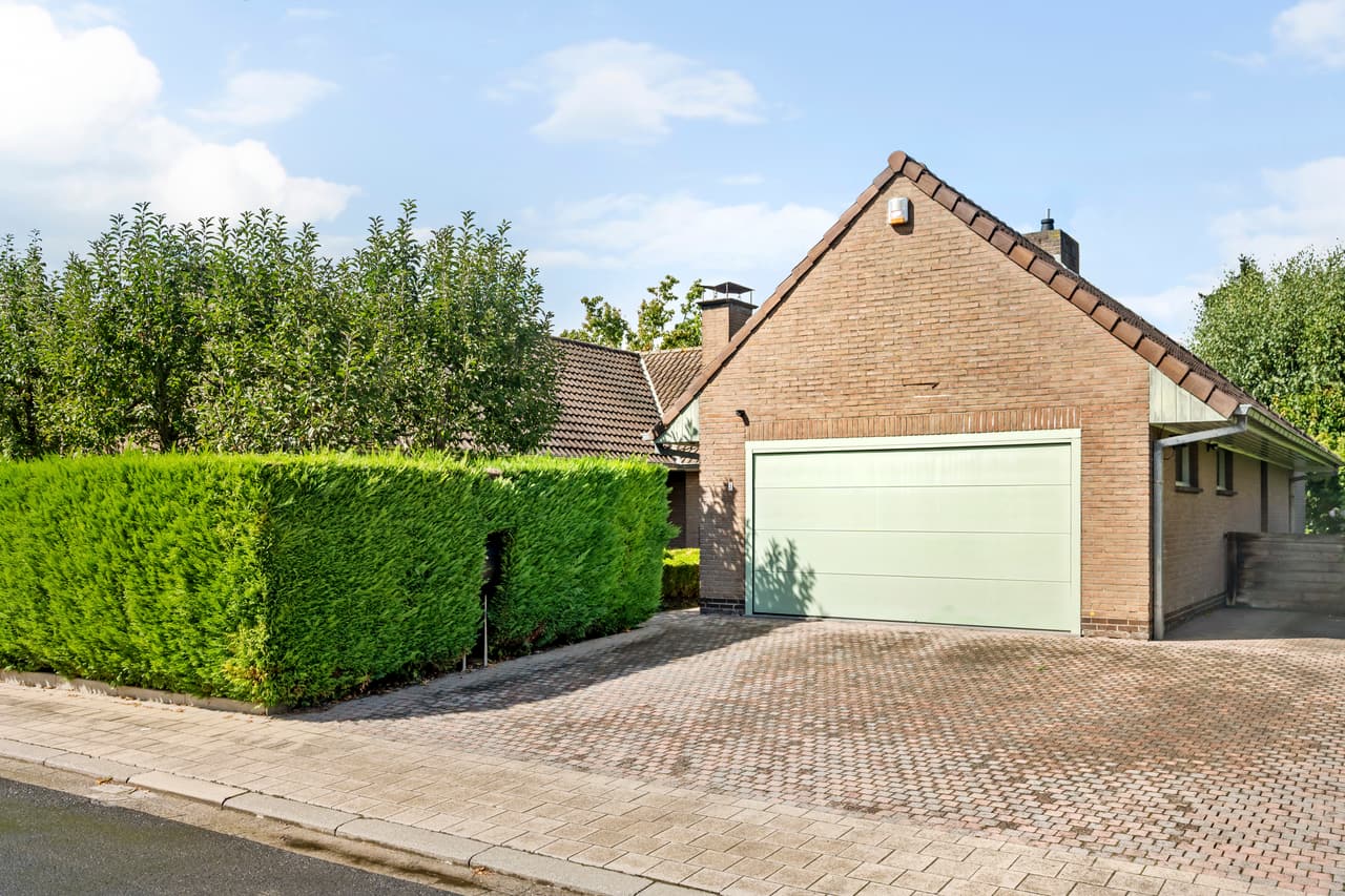 Straatzicht op de villa met oprit en garage